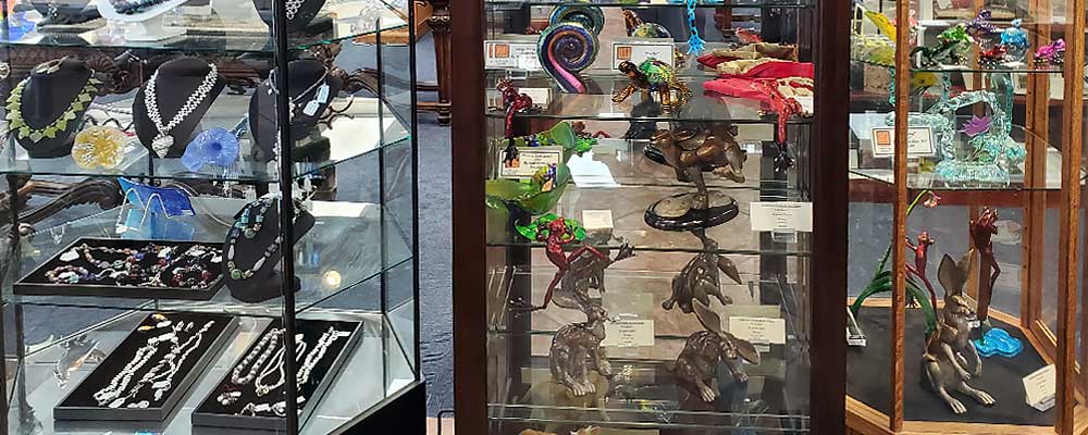 Display cases with jewelry & sculptures - Gold Beach Books & Art Gallery - The Largest Display of Bronze Sculptures in Oregon